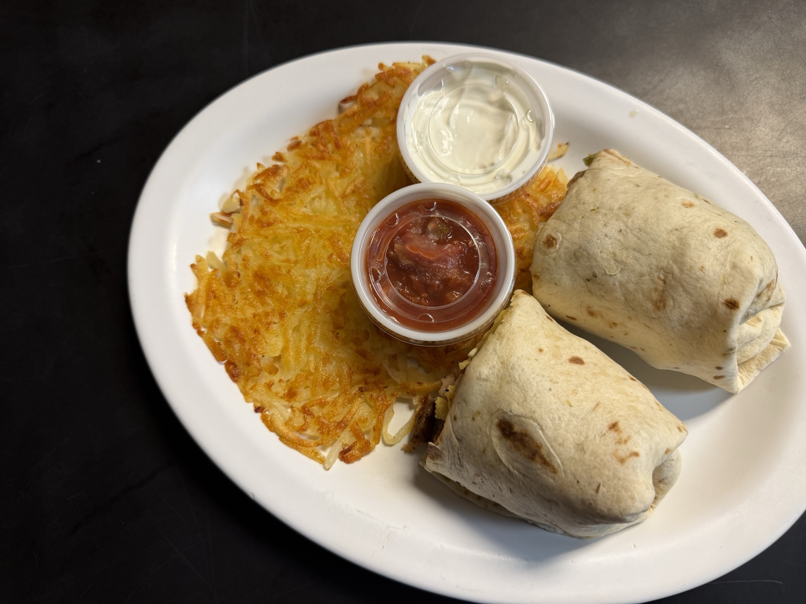 Breakfast burrito with hash browns, salsa and sour cream